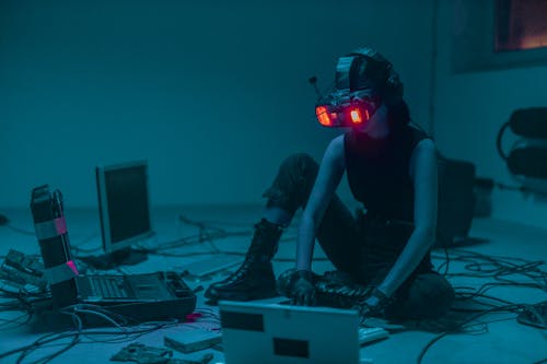 Free A Person Sitting on the Floor with Vr Goggles Using a Computer Stock Photo