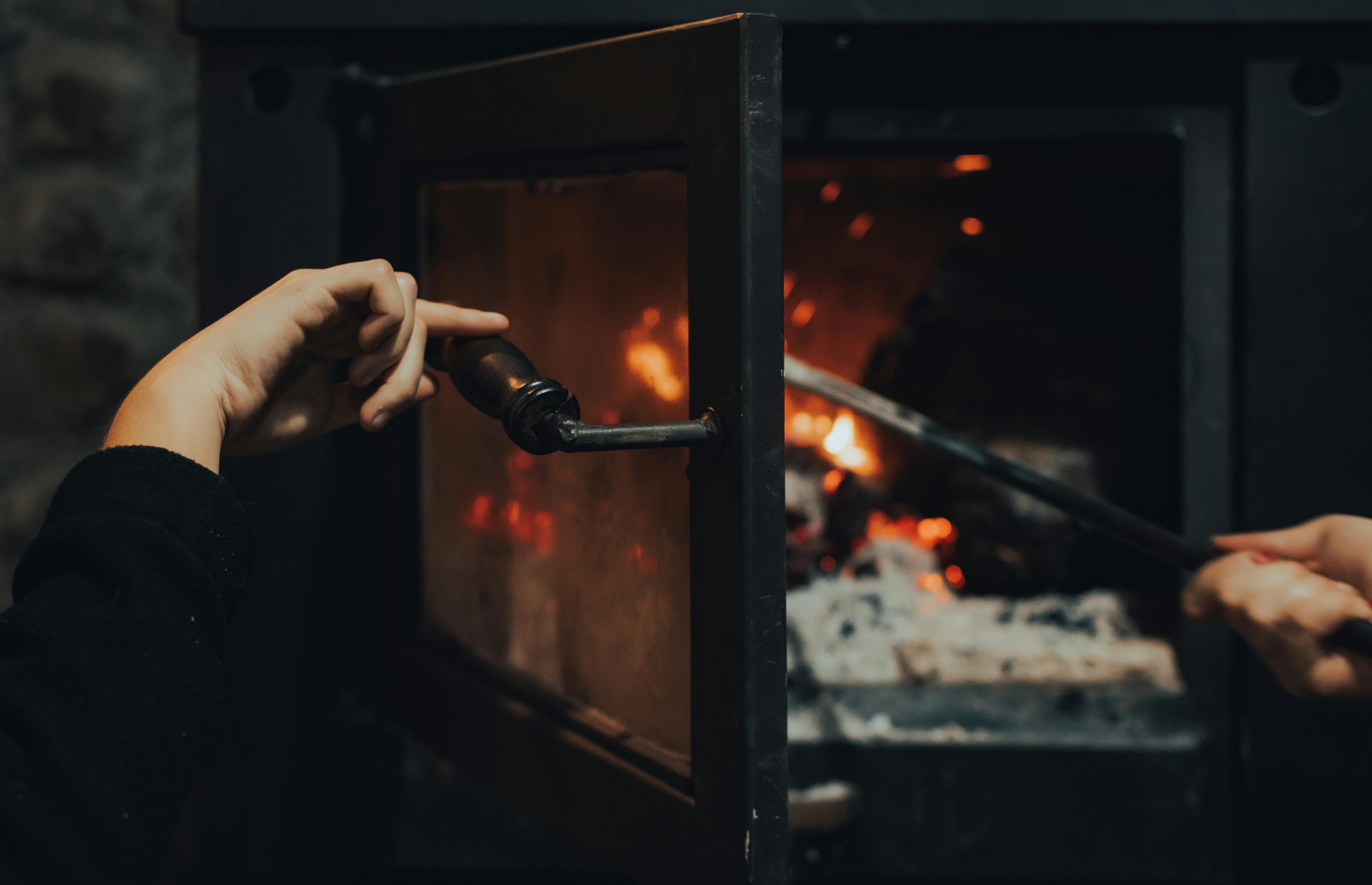 a person pushing the fire woods in the furnace