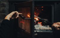 A Person Pushing the Fire Woods in the Furnace