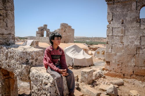 Young Boy Sitting on Ancient Ruins
