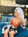 Woman in a Red Swimsuit and a Dog on a Daybed