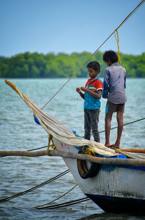 Kostenloses Stock Foto zu fischerboot, fluss, jungen