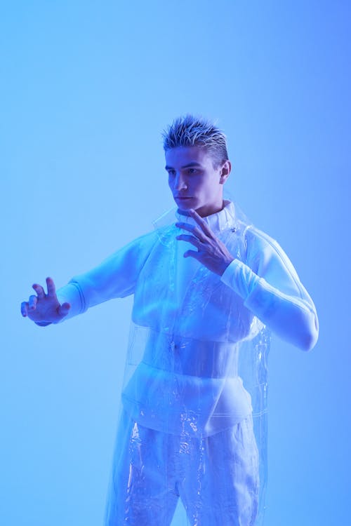 Free A Man in White Clothes with Clear Plastic Coat Illuminated with Blue Light Stock Photo