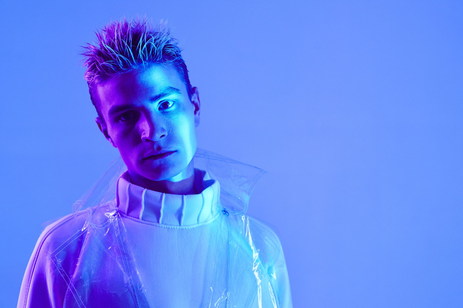 Portrait of a man in futuristic fashion with neon blue lighting.