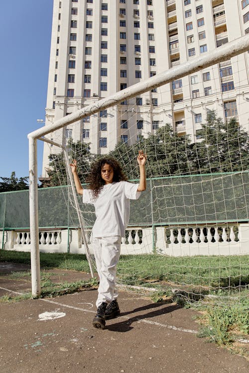 Young Woman Standing by the Goal on a Spots Ground in City 