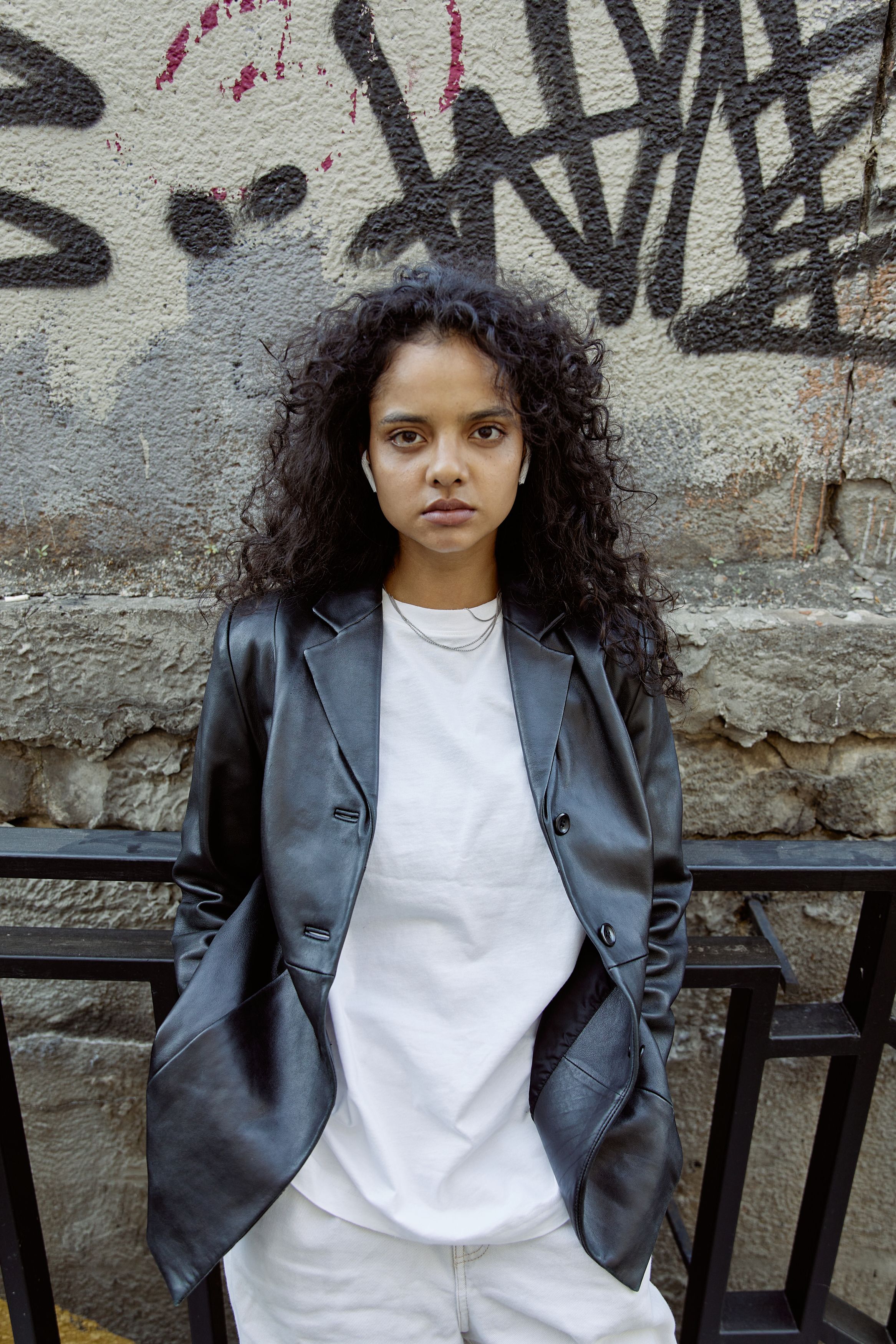 A Woman in Black Leather Jacket Standing Beside Concrete Wall · Free ...