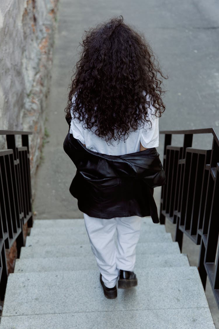 A Woman Walking While Going Down On The Stairs