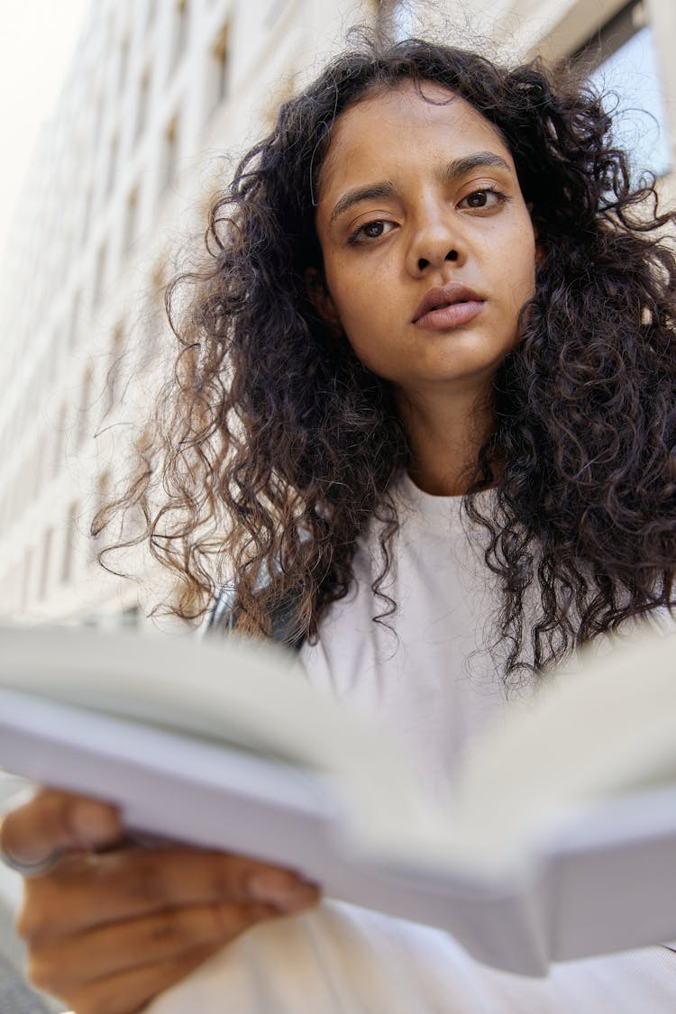 Woman In White Shirt Holding A White Open Book Photo