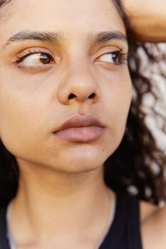 Close-up portrait of a young woman looking sideways with natural expression.