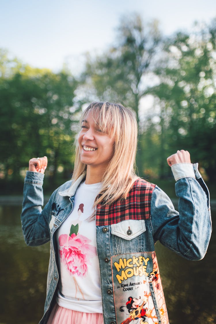 Smiling Young Blonde Woman Wearing A Denim Jacket With Patches 