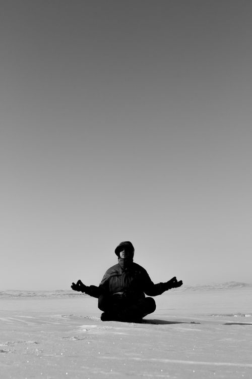 Free Man meditating in a snowy winter landscape, embracing mindfulness and calmness. Stock Photo