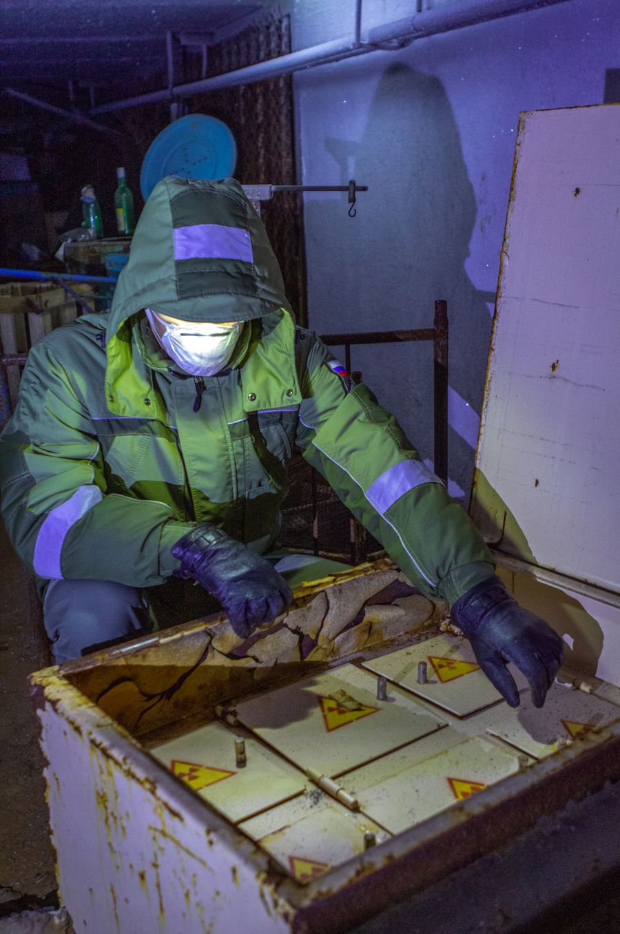 Persona con traje y guantes protectores manipula residuos peligrosos