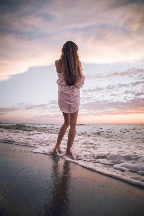 Woman in White Dress Standing on Beach Shore · Free Stock Photo