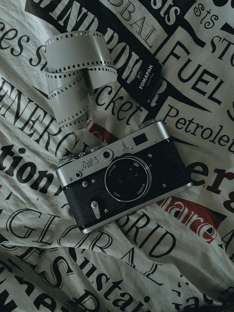 Analog Camera And Strip Of Film On A Printed Fabric