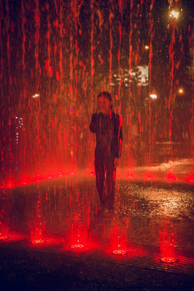 A Child Playing In A Water Fountain