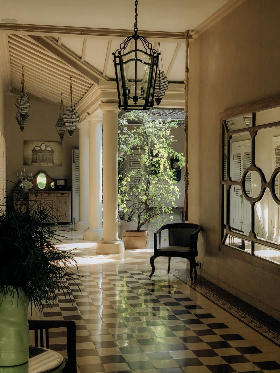 Grand stucco townhouse hallway with checkerboard floor