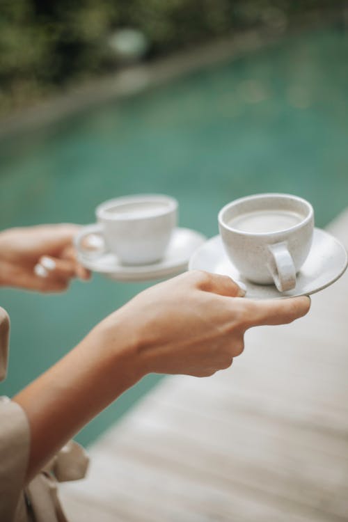 Woman Holding Two White Ceramic Cups