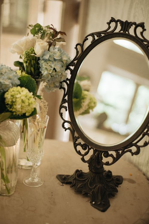 Free Elegant vintage mirror with a bouquet of flowers reflecting softly on a table. Stock Photo