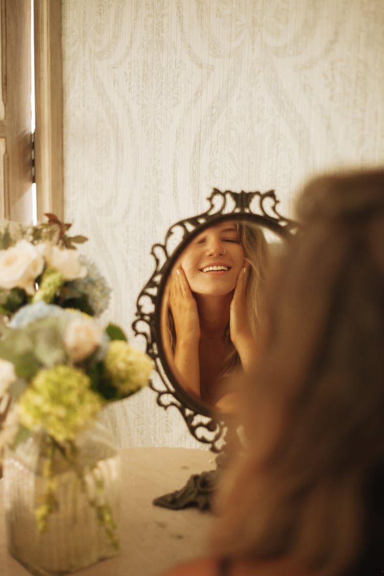 Blond Woman Reflecting In A Mirror And Smiling