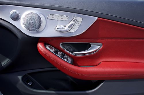 Free Close-up of luxurious car door interior with red leather and metallic controls. Stock Photo