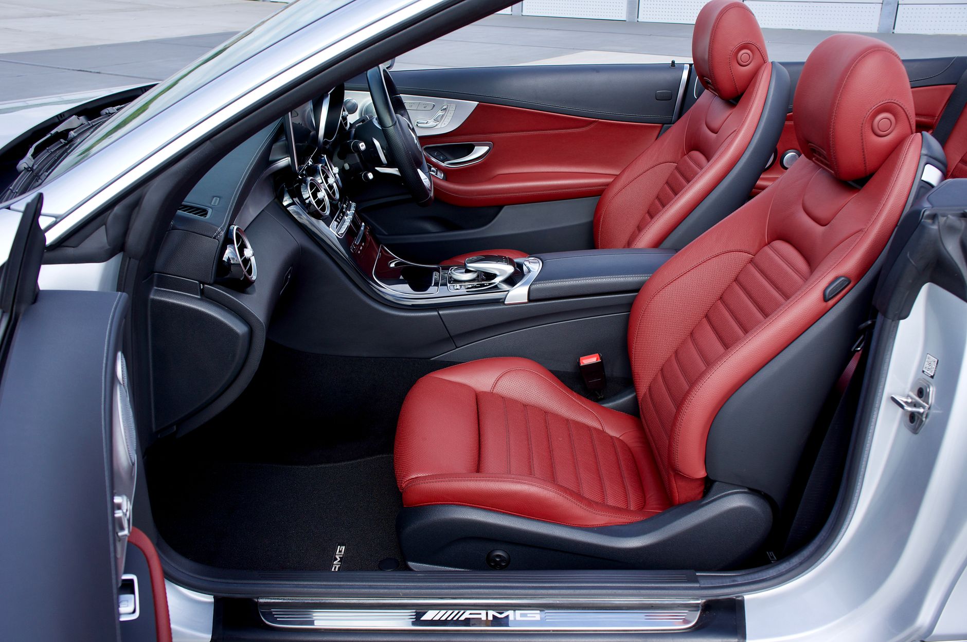 Explore the elegance of a luxury car's red leather interior, showcasing sleek design and AMG branding.