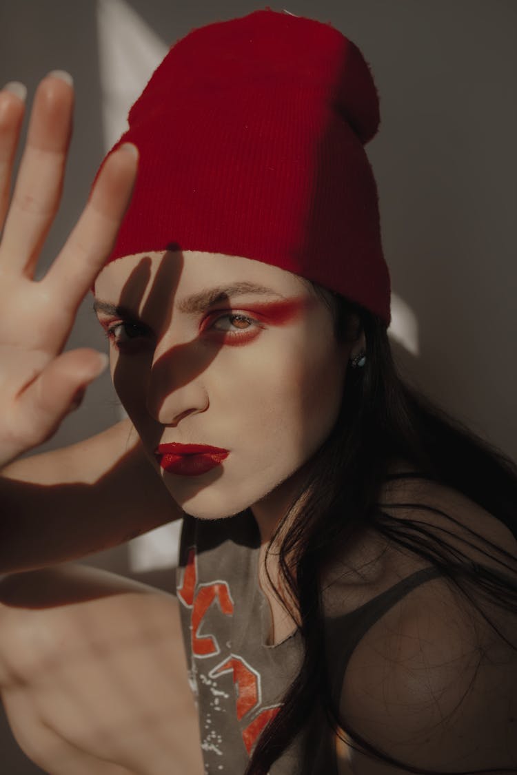 A Woman In Red Knit Cap Blocking The Sun Light From Face