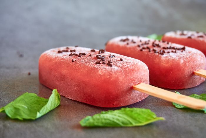 Close-up of red ice pops with mint leaves and chocolate sprinkles