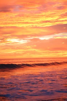 Beautiful ocean waves under a dramatic sunset sky with vivid colors.
