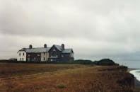 海边悬崖上的一栋老房子，天空阴沉，散发着复古的感觉