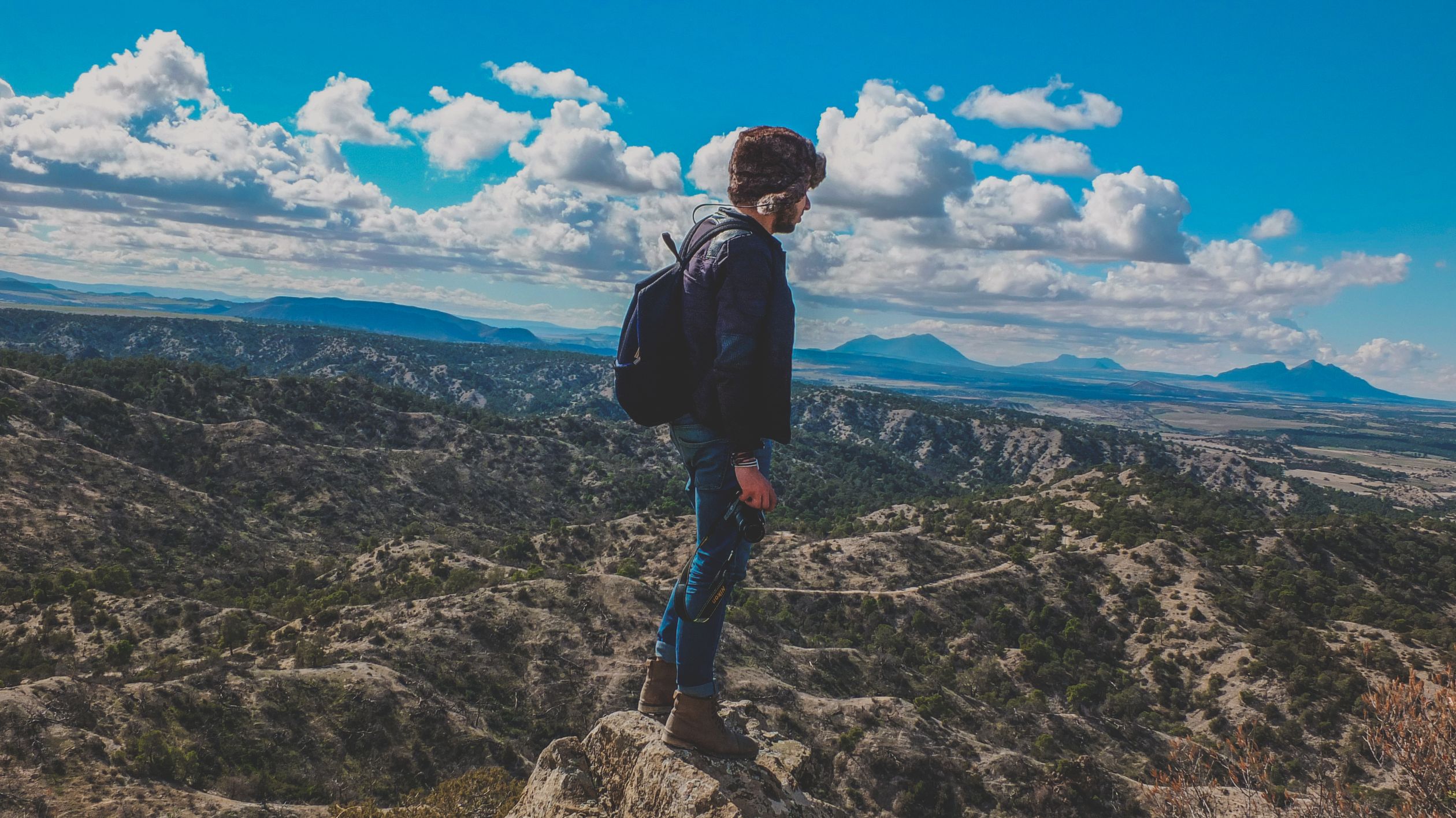 Man standing on a rocky mountain summit under a vivid blue sky