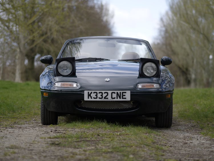 Black Mazda Parked On Grass Field