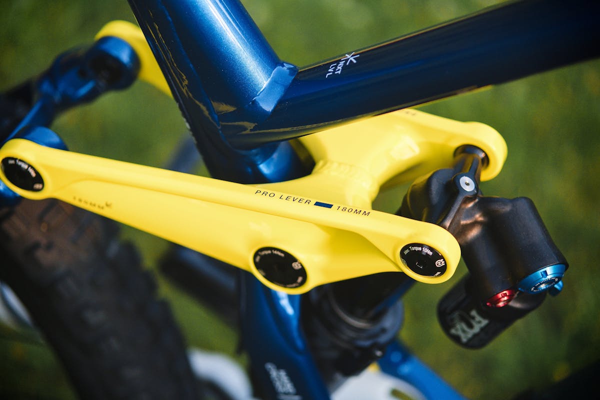 Detailed view of a mountain bike rear shock absorber showing yellow spring and compression adjustment mechanism