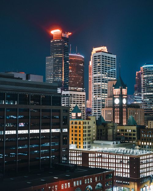 Free Stunning night view of the illuminated Minneapolis skyline featuring iconic skyscrapers and city lights. Stock Photo