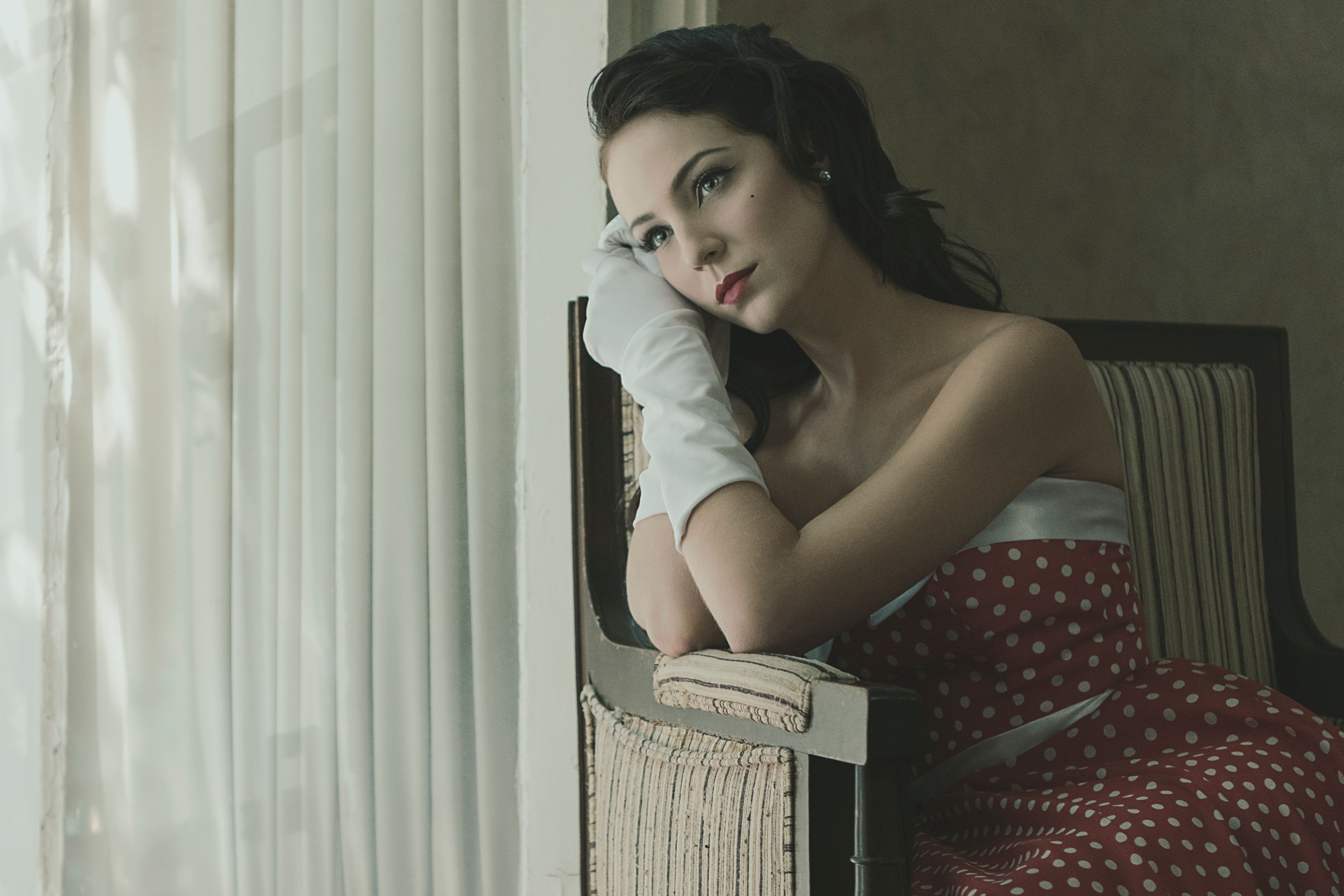 A Woman Wearing a Polka Dot Dress and Gloves Sitting on a Chair · Free ...