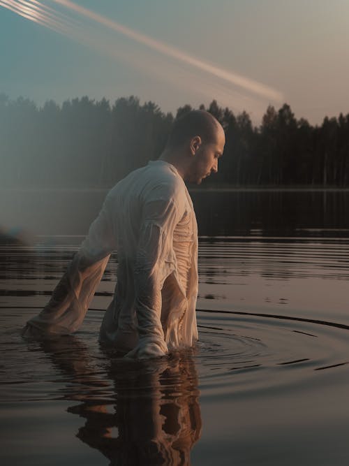 A Man Wearing a White Long Sleeved Top in the Lake