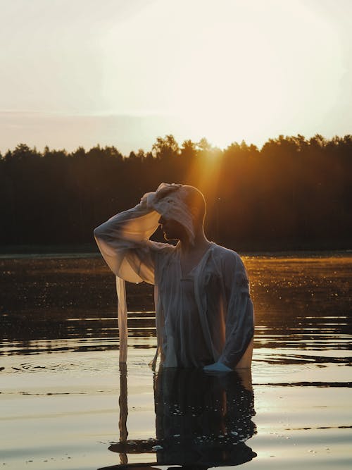 
A Man Wearing a Vintage White Long Sleeved Shirt in the Lake