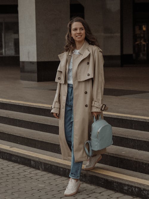 A Woman in Beige Coat Walking Down the Stairs