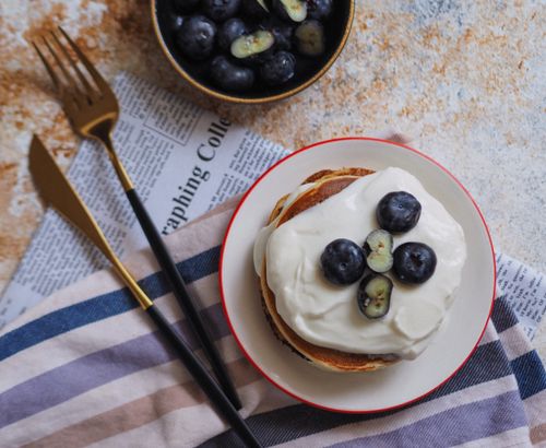 Free Indulge in delicious pancakes topped with creamy yogurt and fresh blueberries. Stock Photo