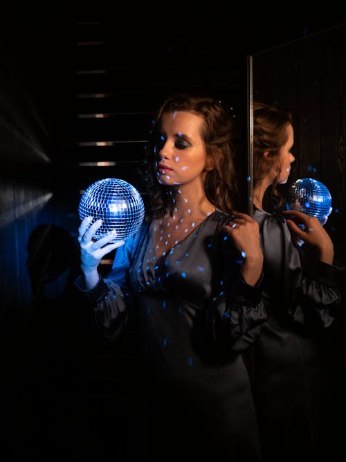 A Woman in a Dress Holding a Disco Ball