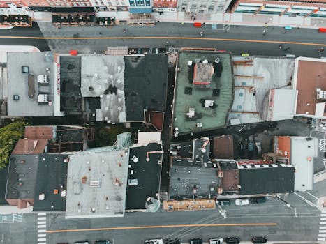 Drone image featuring city rooftops and streets, showcasing urban life from above.