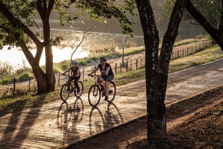 A Boy And Woman Riding Bicycles On The Road