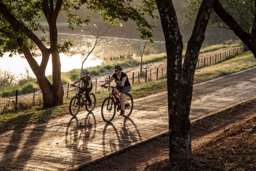 Free A woman and child riding bicycles on a scenic path by a serene lake in Brazil during the day. Stock Photo