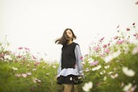 一位年轻女子在生机盎然的花田中，拥抱大自然的宁静