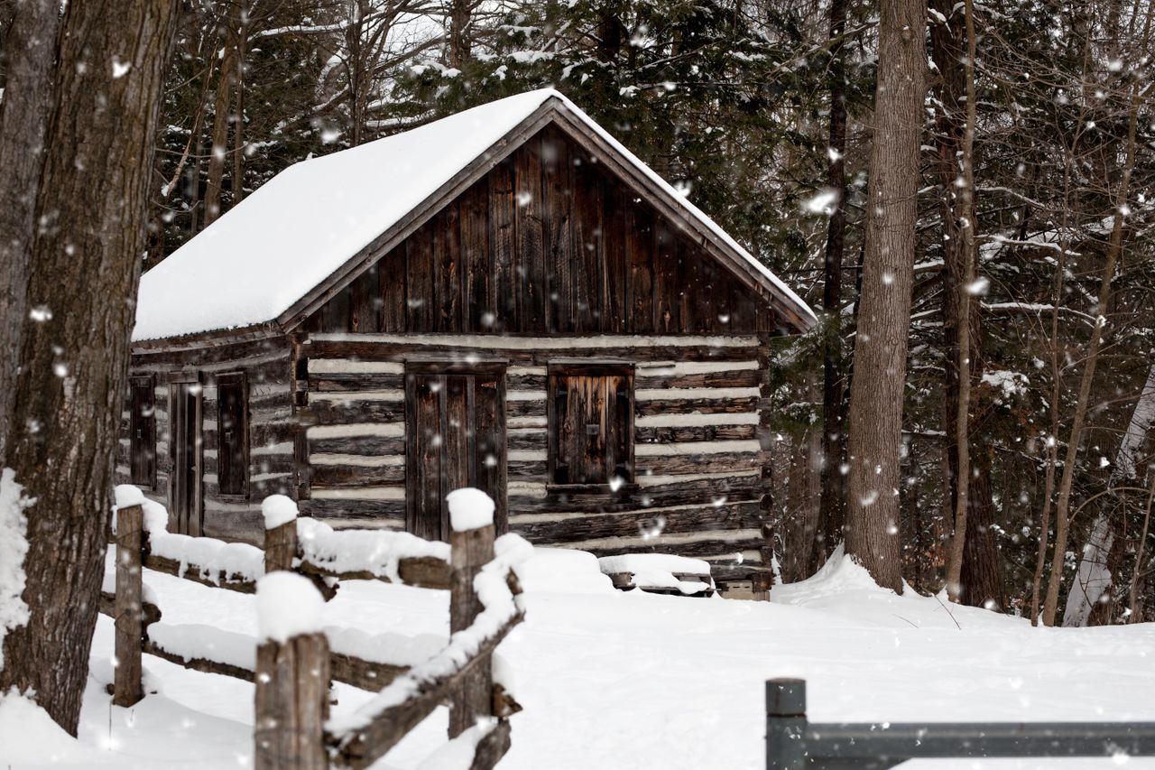 charming log cabin nestled in a snow covered forest evoking a serene w