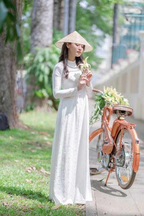 Kostenloses Stock Foto zu ao dai, asiatische frau, blume