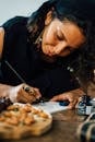 A Woman in Black Shirt Writing on Paper