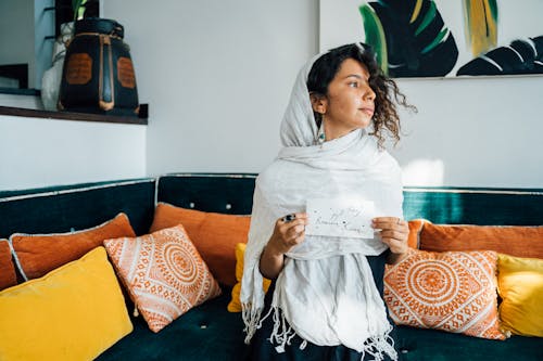 A Woman Wearing a Headscarf While Holding paper