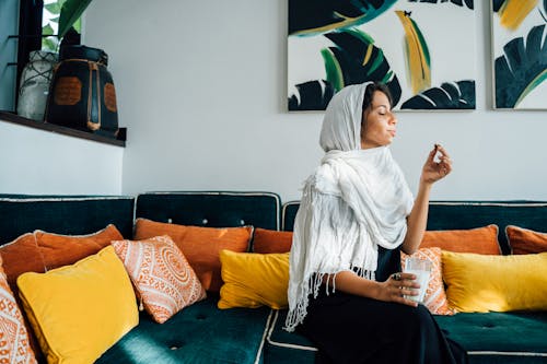 Woman in White Hijab Sitting on Sofa
