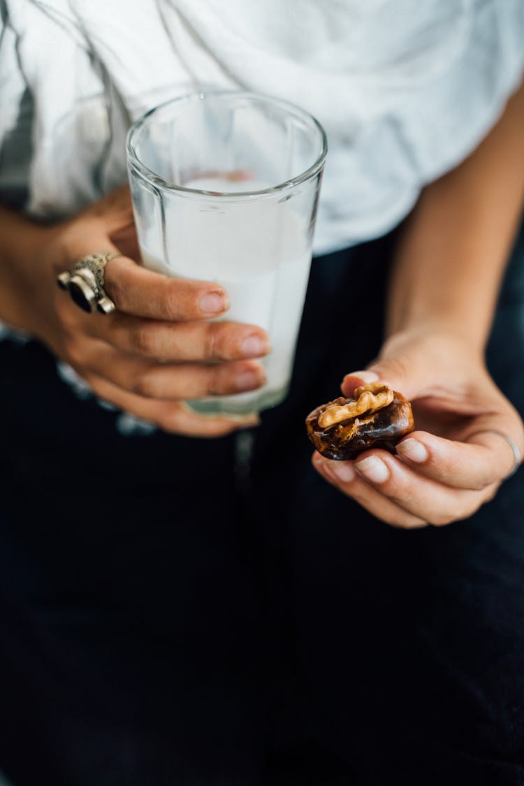 Person Holding Clear Drinking Glass Milk And Cookie