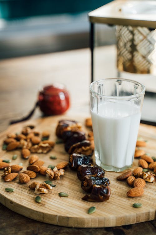 Clear Drinking Glass With Milk and Assorted Nuts